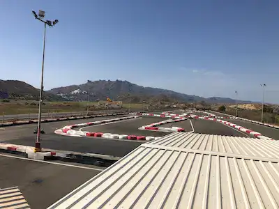 Looking at the Karting Garrucha track from the viewing platform. Hills in the background, ugly flat roof in the foreground.